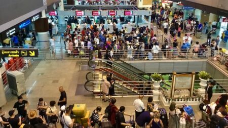 バンコクドンムアン空港で出国の手荷物検査を待つ観光客