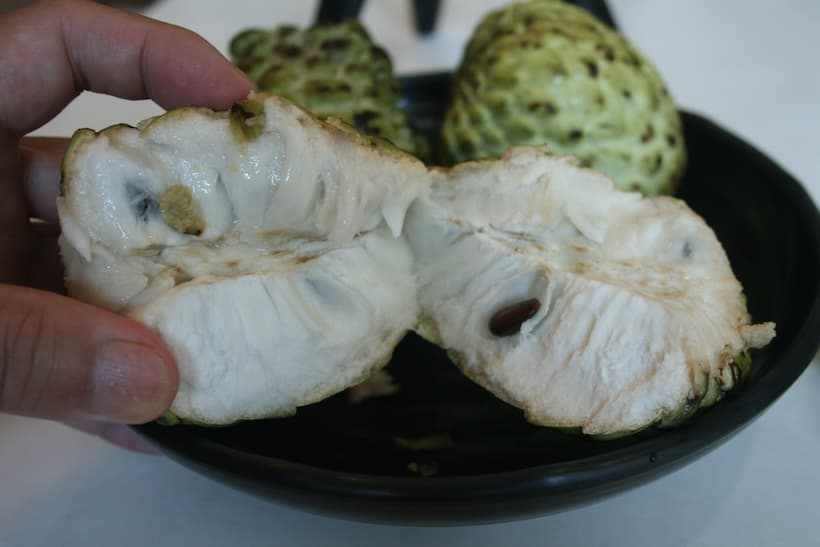 半分に割ったシュガーアップル。甘くクリーミーな果肉が詰まっています。